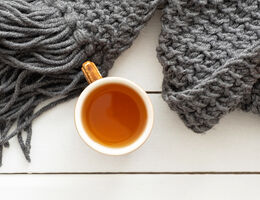 A mug of tea and a knitted scarf.