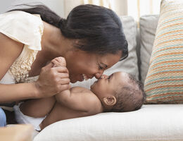  A mother smiles and rubs noses with a baby.